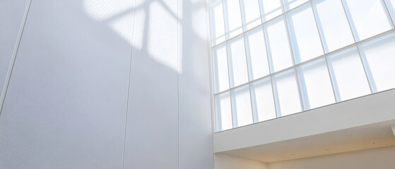 Obraz premium Bright sunlight streaming through large windows in modern architectural space