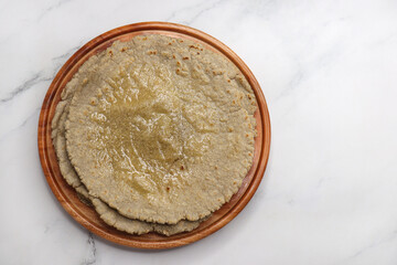 Jowar flour flatbread known as bhakar or jawari bhakri. served with ghee, spicy garlic or lasun chutney, bhindi or lady finger sabji. farmer's food. Maharashtrian village food. copy space.