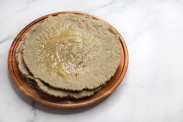 Jowar flour flatbread known as bhakar or jawari bhakri. served with ghee, spicy garlic or lasun chutney, bhindi or lady finger sabji. farmer's food. Maharashtrian village food. copy space.