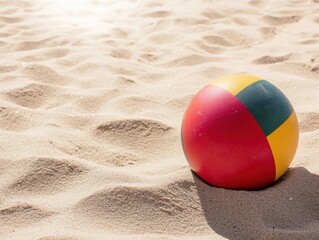 Obraz premium Beach ball halfburied in sand, near a tide line with seaweed, under a blazing summer sun, suggesting playful coastal vibes
