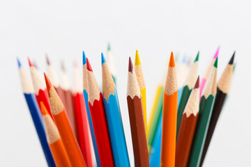 Color wood pencils in a cup on white background, selective focus.