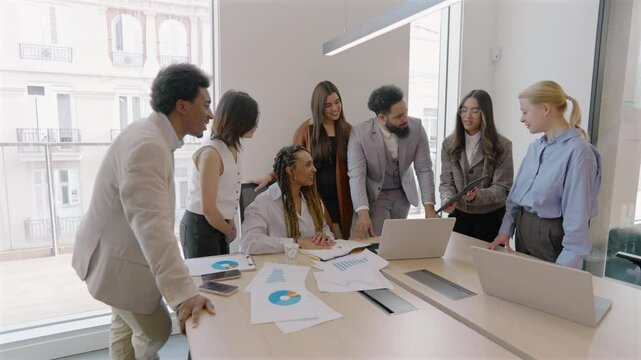 Diverse arrangement of skilled professionals are engaging dynamically around a laptop in a sleek, modern office environment, effectively showcasing the essence of teamwork and collaboration - Powered by Adobe