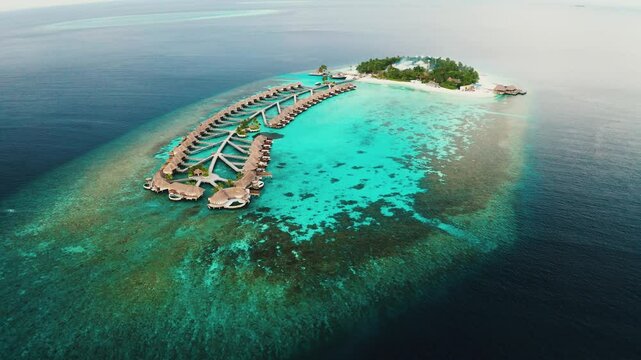 Aerial shot of tropical island paradise W hotel Maldives Sapphire blue waters and atolls surround the luxurious resort. 