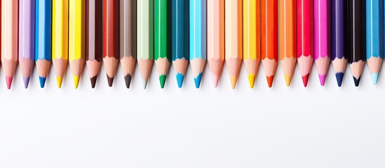 Vibrant colored pencils arranged neatly on a clean white background providing ample copy space with alignment from left to right featuring multiple colors