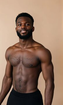 A man with a shaved head and a beard stands in front of a tan wall