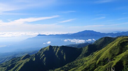 Breathtaking panorama of rolling green hills and majestic mountains under a blue sky