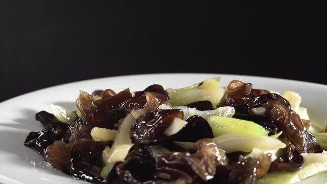 Stir-fried Celery with Wood Ear Mushrooms on black background. Food concept