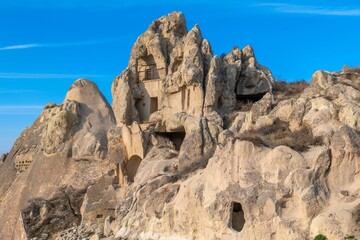 Fototapeta premium Rock formations and cave dwellings in Cappadocia, Turkey under a clear blue sky