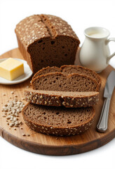 Naklejka premium There is a still life with rye bread, sliced, and seeds on a wooden table. Next to it is a kitchen knife, a jug of milk and butter. white background