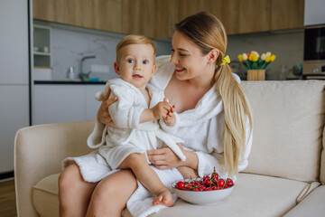 Mother and toddler enjoying snack time together in a cozy living room