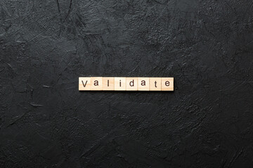 VALIDATE word written on wood block. VALIDATE text on cement table for your desing, concept