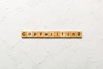 Copywriting word written on wood block. Copywriting text on cement table for your desing, concept