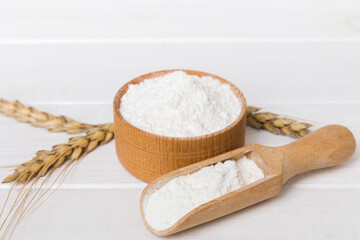 Flat lay of Wheat flour in wooden bowl with wheat spikelets on colored background. world wheat crisis