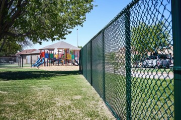 Fototapeta premium Enhancing playground security with sturdy chainlink fence local park outdoor structure green environment side view child safety concept
