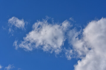A white cumulus cloud in a blue sky, daytime, sunny