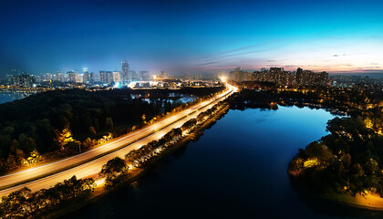 City Lights at Dusk: A breathtaking panorama of a city skyline emerges as dusk descends, with illuminated roads, twinkling buildings, and serene waters mirroring the night sky.