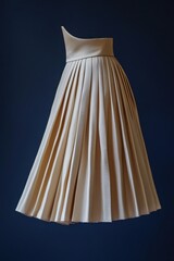 Elegant beige pleated skirt displayed against a dark background showcasing timeless fashion design and craftsmanship