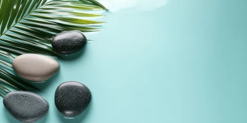 Relaxing spa stones alongside tropical leaves in serene water