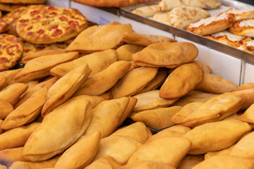 Fried panzerotti with golden crispy crust displayed at an Italian street food stall where traditional baked and fried snacks are sold for locals and tourists in a market