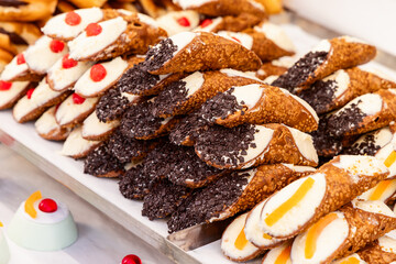 Sicilian cannoli with crispy golden shells filled with sweet ricotta and decorated with chocolate chips candied fruit and cherries