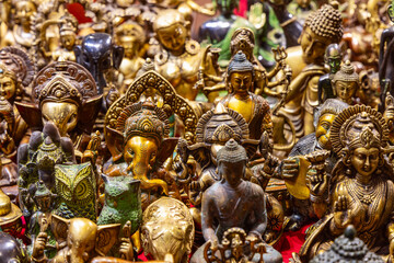 Collection of religious sculptures depicting Hindu and Buddhist gods adorned with symbolic elements including Ganesha and Buddha figures