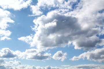 White cumulus clouds on blue sky. Daytime sky with scattered cloud formations. Natural sky with cumulus clouds. Bright blue sky with cloud clusters. Cloudscape cumulus clouds against clear blue sky