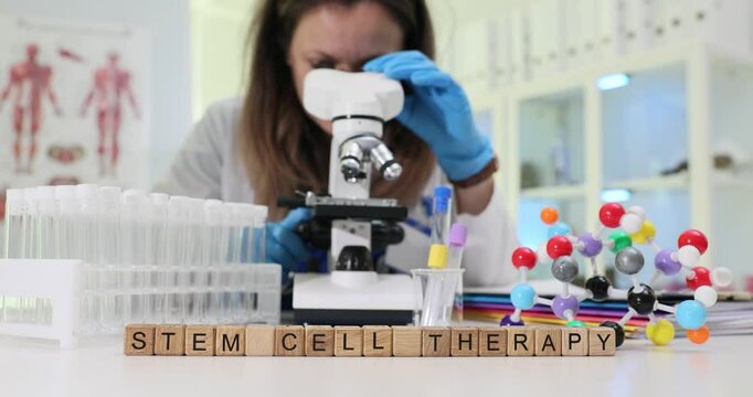 A dedicated scientist studies stem cells under a microscope, showcasing innovative research in therapy and treatment