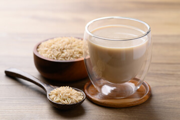Organic rice milk in cup glass on wooden background, Alternative milk made from plant