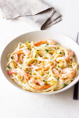 Linguine pasta in creamy garlic sauce with shrimps. Italian food.