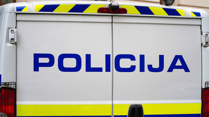police sign on police car slovenia.Ljubljana police.A police vehicle is parked with its doors closed, displaying a large blue lettering that reads POLICIJA. © Illia Holovko