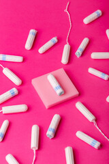 Many menstrual hygiene tampons from above on pink background. Soft cotton absorbent menstrual tampons for women during menstruation. Feminine hygiene. 