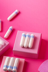Many menstrual hygiene tampons from above on pink background in beautiful composition. Soft cotton absorbent menstrual tampons for women during menstruation. Feminine hygiene. 