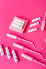 Many menstrual hygiene tampons from above on pink background in beautiful composition. Soft cotton absorbent menstrual tampons for women during menstruation. Feminine hygiene. 