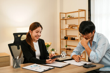Businesswoman embraces client after successful property negotiation.