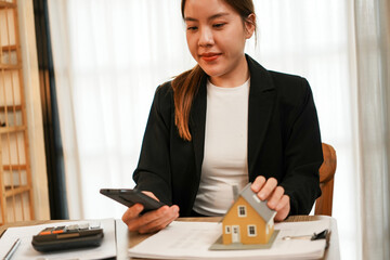 Businesswoman embraces client after successful property negotiation.