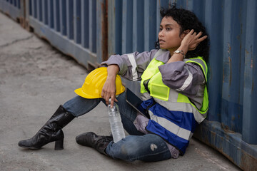 Container industry person sitting at warehouse cargo container ship tired of overworked. Female...