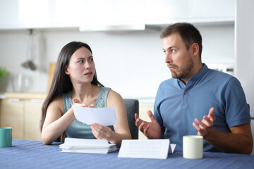 Asian woman scolding her partner holding bank statement