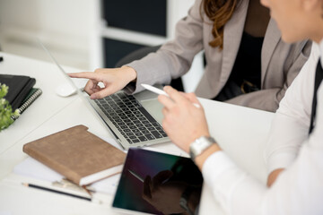 An Asian female executive is discussing marketing plans with a senior officer in a conference room.