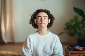 Calm atmosphere with young woman enjoying music, eyes closed, se