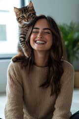 Smiling woman enjoys cozy moment with playful cat on her shoulde