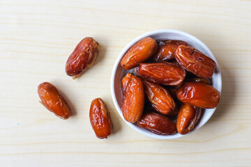 Tunisia dates in white bowl, sweet dried dates palm fruits. on wooden table