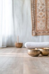 Calming interior featuring bowls on wooden floor, soft textiles
