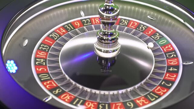 Close-up of a roulette wheel spinning with the ball landing on a number, against a green screen background