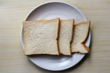White plain breads in white plate. Overhead shot of sliced white bread.