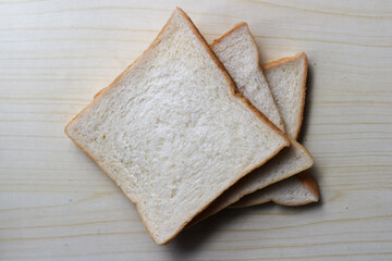 White plain breads on wooden table. Overhead shot of sliced white bread.