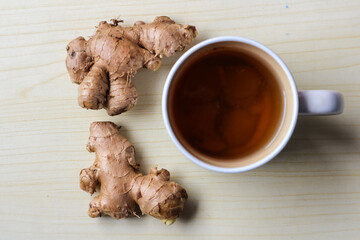 Cup of hot ginger tea with ginger root