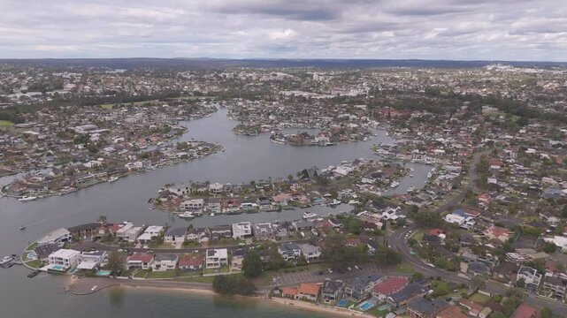 Stunning bird&rsquo;s-eye aerial footage flying over luxurious waterfront homes in Sylvania Waters, Sydney, Australia, showcasing beautiful residential properties and serene coastal views.