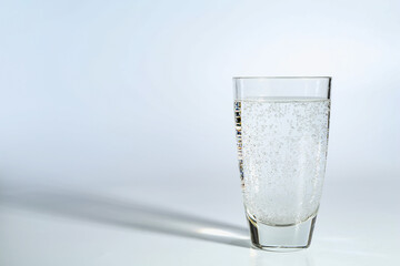 Refreshing soda water in glass on light background. Space for text