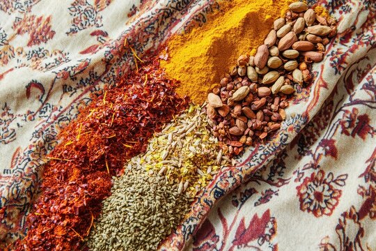 Explore the vibrant flavors of saffron, turmeric, paprika, and cumin arranged artistically on a colorful patterned cloth. Generative AI