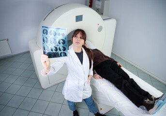 Female radiologist with a patient in a scanning room. Adorable doctor in CT scan room. Radiologist...